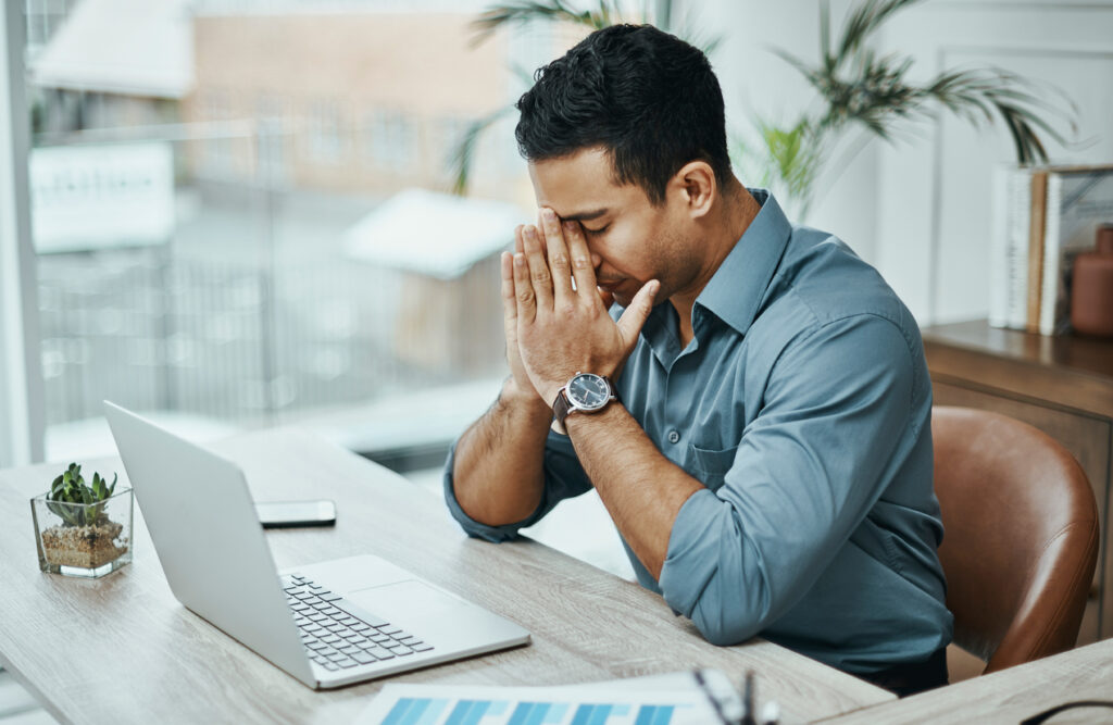 Shot of a young businessman looking stressed while working in a modern office because he got ghosted by a company in the hiring process.