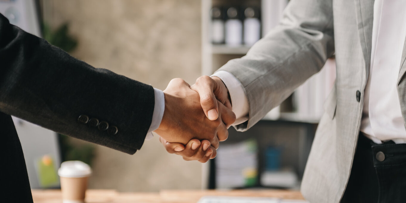 Two confident business man shaking hands during a meeting in the office, success, dealing, greeting and partner